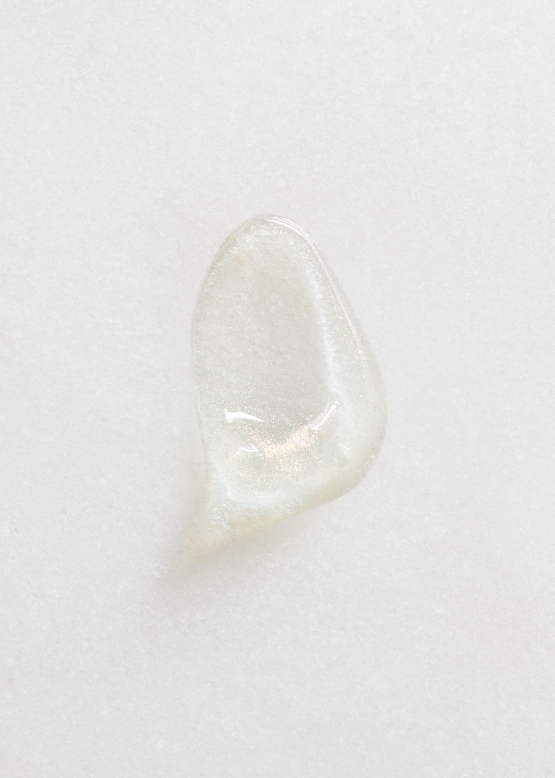 Smear of clear and shimmering Performance Eye Gel on white background.